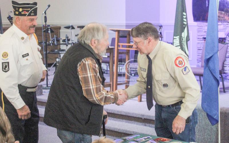 Todd Gawel (right) presented lapel pins and certificates to veterans who attended a ceremony commemorating National Vietnam War Veterans Day Sunday at Gladwin Assembly of God.