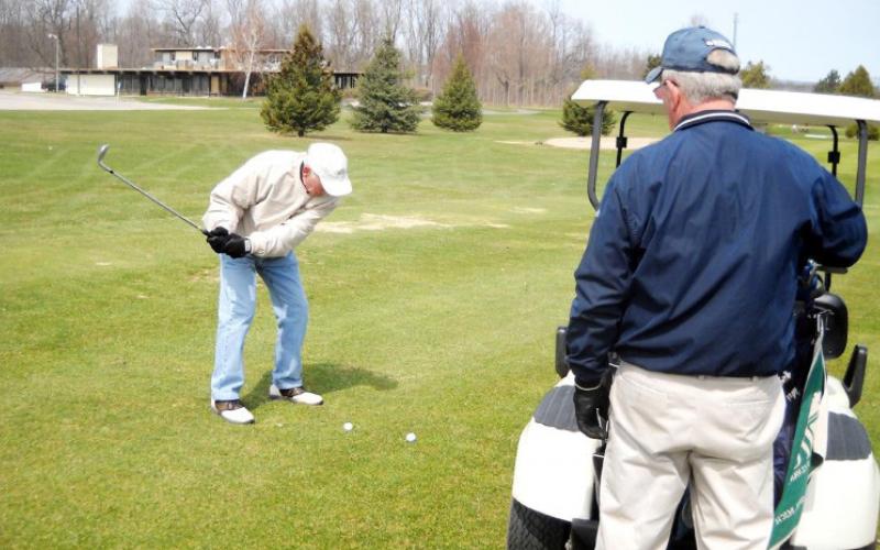 Pat Boruszewski, of Gladwin, took a shot at the opening of Sam’s Scramble on April 15, 2011, Gladwin Heights Golf Course, while threesome partner, Paul Ninelist, of Beaverton, looked on. Sam’s Scramble has taken place for many years.
