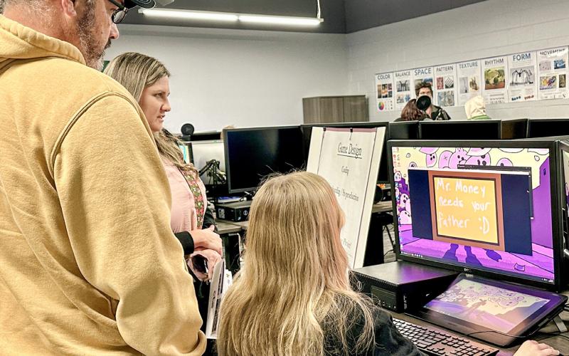 A Digital Media student interacts with visitors in the new lab, demonstrating industry-standard software and equipment while explaining how the program helps build technical skills.