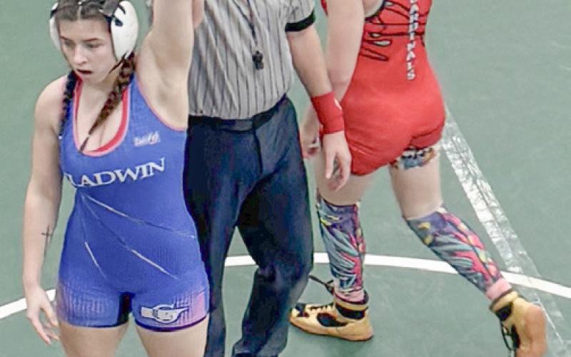 Gladwin’sBrielleMcKinnon has her hand raised in victory after winning the district championship at 155 Sunday at Grayling.