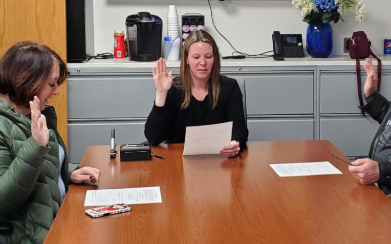 Trustees Jane Zdrojewski (at left) and Mike Jankoviak (at right) are sworn in by Fassett.