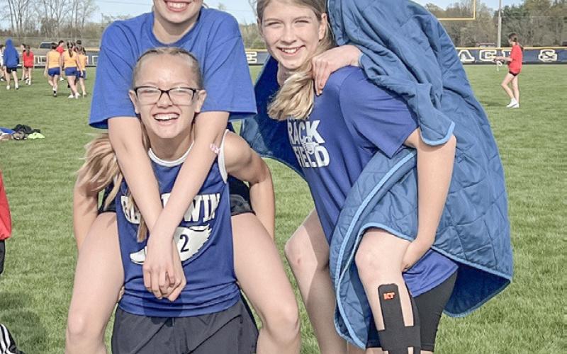 Lily Leinenger and Aria Rule get lifts from Ava Kiger and Avery Graybill after competing in the 400 relay at a junior high track meet last week.