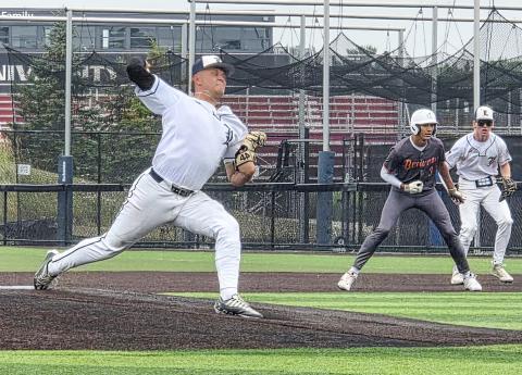Mason Meier delivers a pitch versus the Beavers in the Panther Classic. Beaver player Garrison Zuker leads off first base as Bryce Neitzel looks on. GRAND RAPIDS