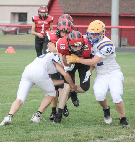 Beaverton’s Mitchell Malmo tries to split two Harrison defenders during Thursday’s junior varsity victory for the Beavers.