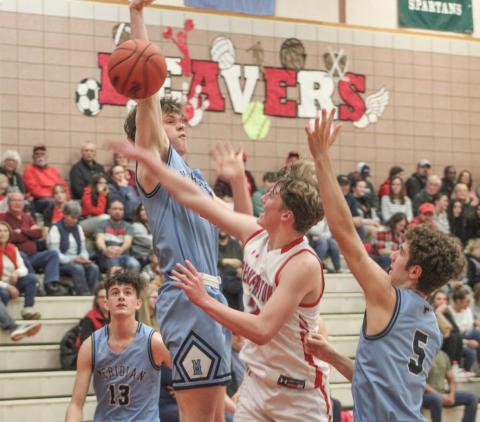 Beaverton’s Ian Roberts contests a Meridian shot in the paint during Friday night’s loss to the top team in the Jack Pine Conference.