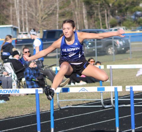 Gladwin’s Elizabeth Huisjen goes up and over on her way to a victory in the 100 hurdles during last Wednesday’s meet.