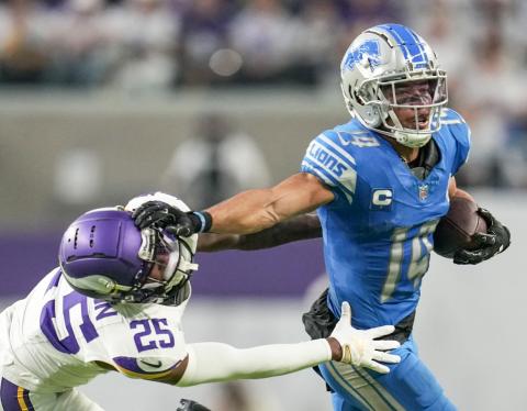 Detroit Lions wide receiver Amon-Ra St. Brown (14) breaks a tackle by Minnesota safety Theo Jackson (25) during the second half of an NFL football game, Sunday, Dec. 24, 2023, in Minneapolis. The Lions won 30-24. AP PHOTO/ABBIE PARR