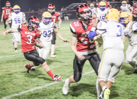 Beaverton’s Kamdyn Avila dodges would-be Harrison tacklers during Friday night’s Homecoming game.