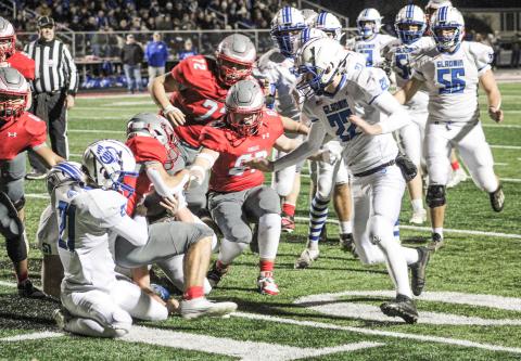 Gladwin’s Talon Goodwin finishes off a gang tackle with Jacob Pahl closing in during the first quarter of Friday night’s 35-0 loss at Frankenmuth in the third round of the Division 5 playoffs.