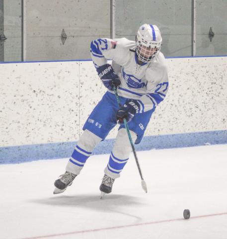 Gladwin’s Logan Shell tries to control a rolling puck as he moves toward the slot during Saturday’s loss to Petoskey.