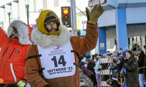 Defending champion Brent Sass, wearing bib No. 14, waves to the crowd during the Iditarod Trail Sled Dog Race’s ceremonial start in downtown Anchorage, Alaska, on Saturday, March 4, 2023. Sass withdrew from this year’s race, Saturday, March 11, 2023, citing concerns for his health. AP PHOTO/MARK THIESSEN