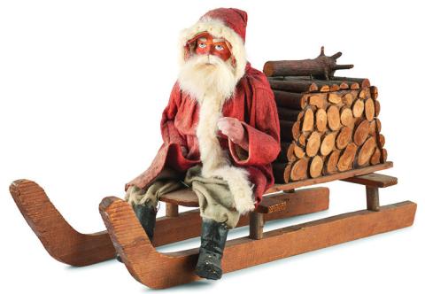 Leave it to Santa Claus to fill a bundle of firewood with candy! This papier-mache figure of Santa on a sled is a candy container. KOVELS.COM