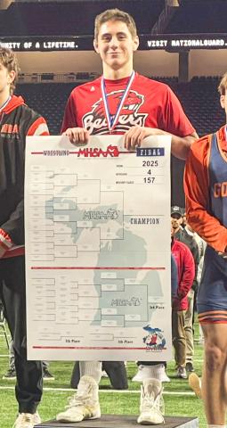 Beaverton’s Eli Roe rules the podium at Ford Field in Detroit after winning the Division 4 state championship at 157 pounds at the individual state meet Saturday.