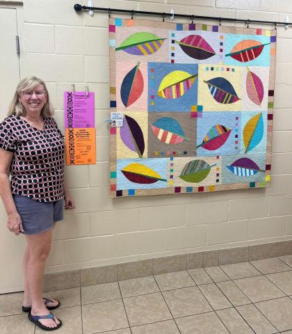 One of two beautiful quilts to be auctioned off during the show. Pictured is local artist Jan Berg-Rezmer, who made this quilt.