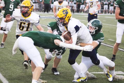 Standish-Sterling quarterback Malachi Schaenzer is wrapped up by a pair of Clare tacklers during Friday night’s victory for the Pioneers.
