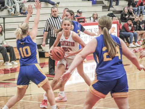 Beaverton’s Myah Hubble drives past one defender and gets ready to try and split two more during Friday night’s 54-24 victory over visiting Harrison.
