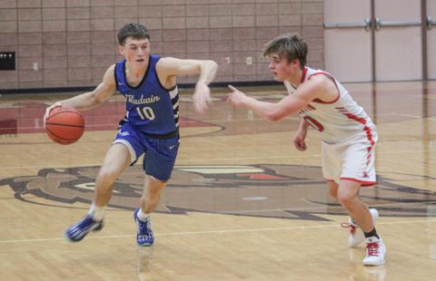 Gladwin’s Seth Mead fends off the defensive pressure applied by Beaverton’s Caiden Loar last Monday night as the Flying G’s won the Battle For Butch.