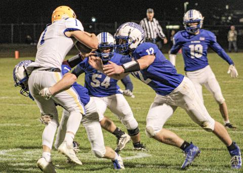 Gladwin’s Mason Cameron, Jaden Tyra and Jeff Zeitz meet at the quarterback for a sack during Friday night’s victory over visiting Harrison.