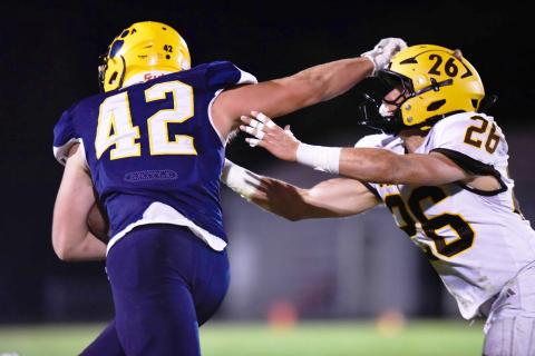 Standish-Sterling’s Rylee Blanchard employs the stiff arm to ward off Ogemaw Heights tackler Lane Winter during the Falcons shutout victory Friday night.