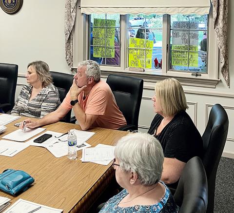 The signs of the times are displayed in the window of City Hall behind (left to right) City Administrator Kimberly Hines andCouncil Members John Caffrey and Jaimie Esiline during Monday night’s Regular Meeting.