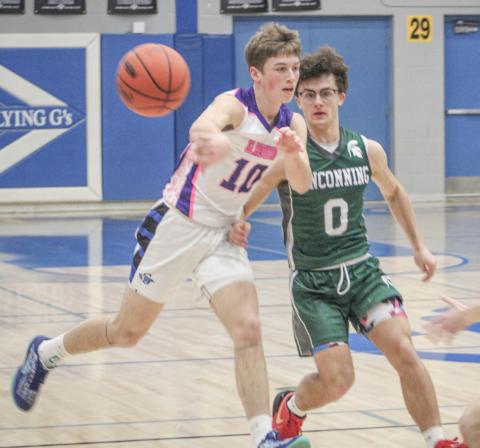 Gladwin’s Seth Mead drives and dishes during last Wednesday’s victory over visiting Pinconning in the school’s annual Coaches Vs. Cancer game.