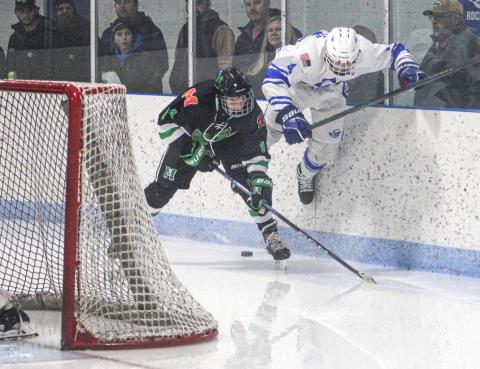 Gladwin’s Ike Wheeler gets up to try and power through a check behind the net Friday night when the Flying G’s and Manistique battled to a 2-2 tie.