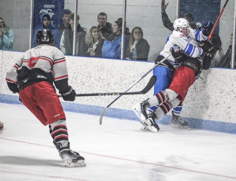 Gladwin’s Hunter Simpson checks in behind the net with a big hit on a Jackson United rival during Saturday’s home opener.
