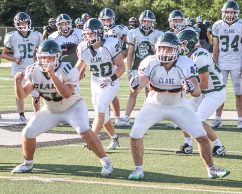 Clare’s offensive linemen get ready for battle before last week’s four-way scrimmage. The Pioneers kick off the season tomorrow night at Grayling.