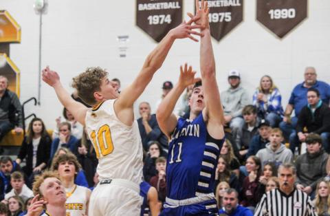 Gladwin’s Nick Wheeler shots from long distance as Ogemaw Heights defender Sawyer Dack tries to block.