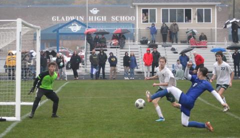 Gladwin’s Connor Ritchie stretches to the limit to try and make a play in front of Freeland’s goal during the district championship game.