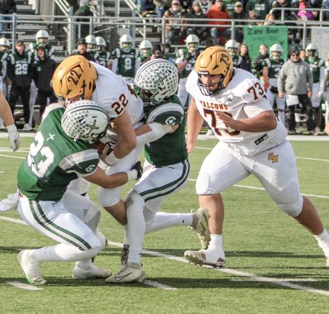 Ogemaw Heights’ Connor Lambert is taken down by two Grand Rapids West Catholic tacklers during Saturday’s state semifinal at Clare.