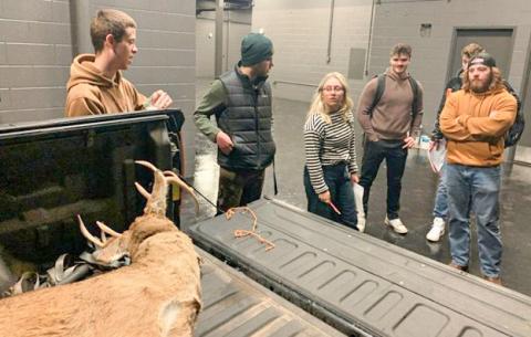 Northern Michigan University students examine a fake deer carcass loaded in the back of a hunter’s truck. Students in the university’s Conservation Law Enforcement program investigate several mock crime scenes to learn how to investigate environmental crimes. JEREMY SERGEY