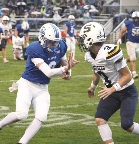 Gladwin’s Bronson Bigham wards off a would-be Shepherd tackler with a stiff arm. The junior scored two touchdowns and passed for a two-point conversion in Friday’s Homecoming victory.