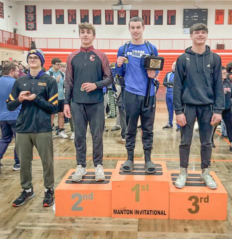 Gladwin’s M.J. McDonald poses on the podium after winning his weight class championship and being named MVP at a tournament at Manton Saturday.