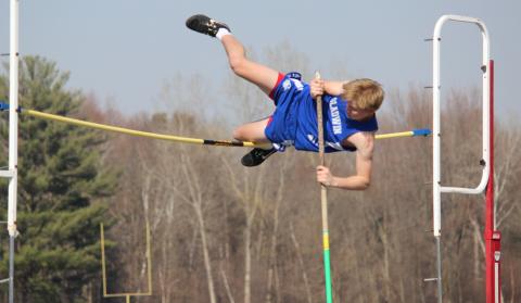 High in the air, Gladwin looks to vault over the pole without knocking it over. Inset photo, Gladwin closely follows Houghton Lake as they compete in hurdle competition.
