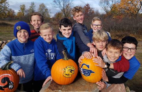 The boys posing with a pumpkin painted by the host school art classes.