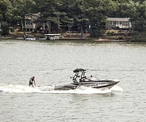 A wake boat tugging a wakeboarder cuts across Brooks Lake on a recent weekend afternoon. EMILIO PEREZ IBARGUEN/BRIDGE MICHIGAN