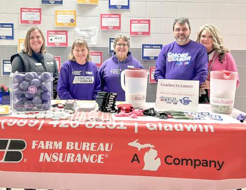 Taking care of the Farm Bureau Insurance sponsor’s table at last year’s Coaches vs. Cancer basketball game at Gladwin were (left to right) Mary Lynn Robertson, Kim Beebe, Heidi Varner, Duane Simpkins and Lisa Simpkins.