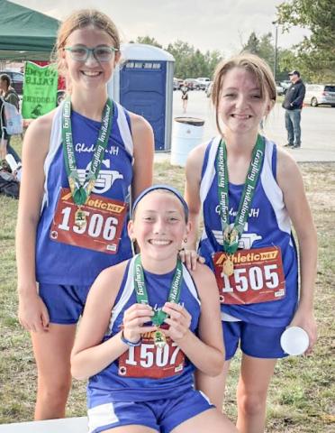 Chloe Johnson, Vada Povey, and Izzy Hurst with their medals from the Grayling Invitational.