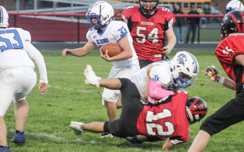 Gladwin’s Max Barz blocks Beaverton’s Nate Diamond to create running room for Ryan Quick during the Flying G’s junior varsity victory. BEAVERTON