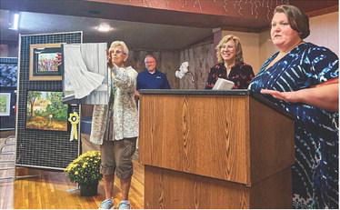 Gladwin High School Art Instructor Amber Billman awarding ribbons at the annual Fall Art Show.