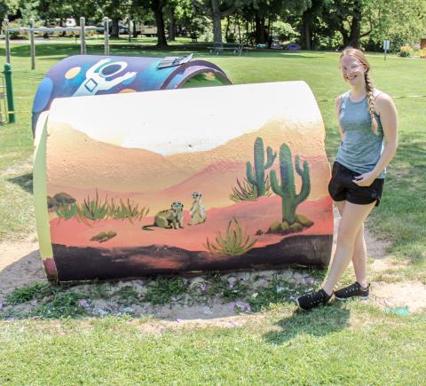 High school student paints City Park playground equipment