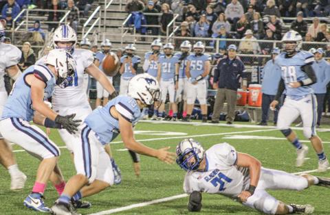 Gladwin’s Matthew Lechner forces a fumble up into the air that was eventually recovered by Kaden Reid during Friday night’s victory at Meridian.
