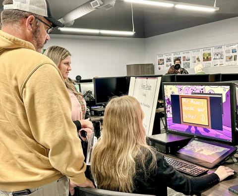 A Digital Media student interacts with visitors in the new lab, demonstrating industry-standard software and equipment while explaining how the program helps build technical skills.