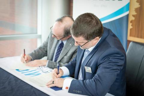 Scott Mertes (Mid) and Sean Burke (Alma), Provosts of their respective institutions, sign the agreement.
