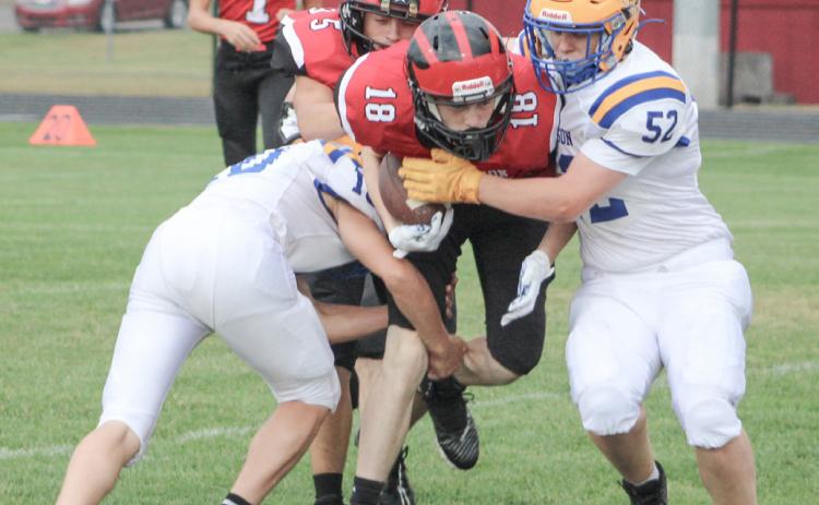 Beaverton’s Mitchell Malmo tries to split two Harrison defenders during Thursday’s junior varsity victory for the Beavers.