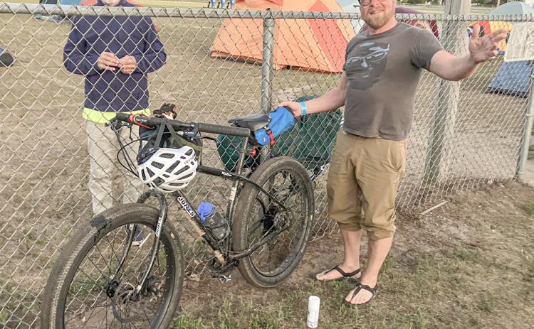 DALMAC ride cyclist Keith Buchley (right) of Lansing relaxes before spending Thursday night in the parking lot at Gladwin High School on his way to Mackinaw City.