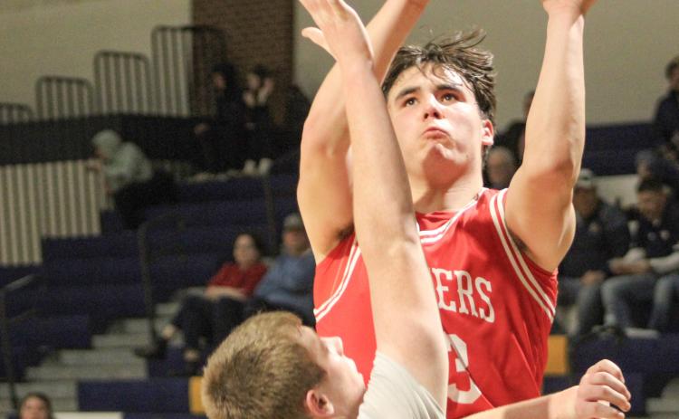 Beaverton’s Landon Love goes up and over a Shepherd defender during a victory Thursday night that clinched the Jack Pine Conference Division 2 title for the Beavers.
