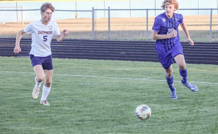 George Whittaker looks toward the front of the net as he closes in on the ball during last week’s district tournament game.