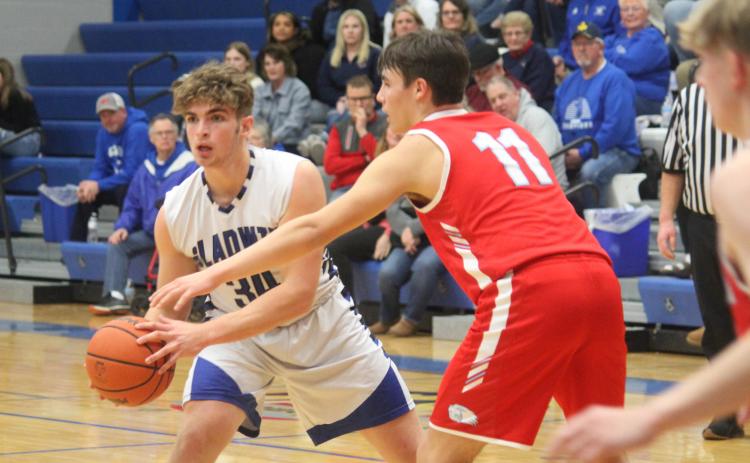 Gladwin’s Connor Dee, guarded by Beaverton’s Landon Love, looks for an open teammate to pass to.